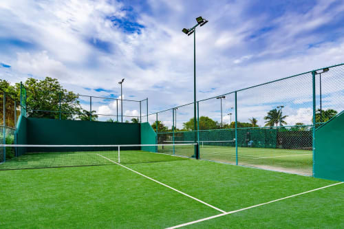 Canchas de tenis profesionales en el Resort Mareazul frente al mar en Playa del Carmen con malla verde e iluminación