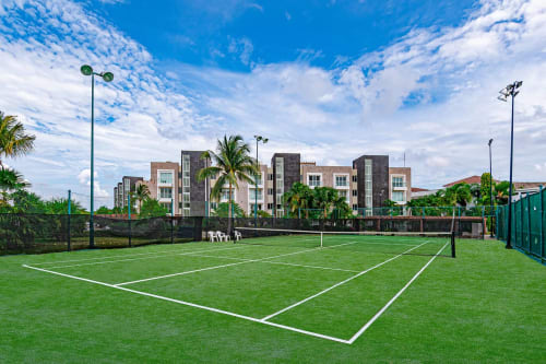Canchas de tenis profesionales en Mareazul Resort Frente al Mar, Playa del Carmen, con apartamentos modernos y palmeras tropicales