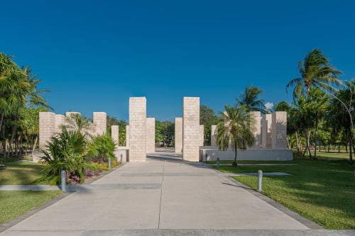 Entrada de monumento moderno en hormigón con palmeras en el resort frente al mar Mareazul en Playa del Carmen