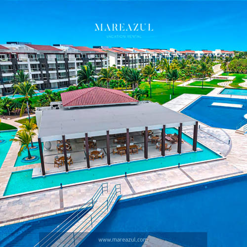 Resort frente al mar Mareazul en Playa del Carmen con piscinas turquesas, cabañas modernas, palmeras y diseño contemporáneo