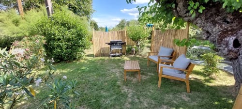 Patio privé du Mas de Trépeloup avec salon de jardin, barbecue et verdure paysagée à Alès