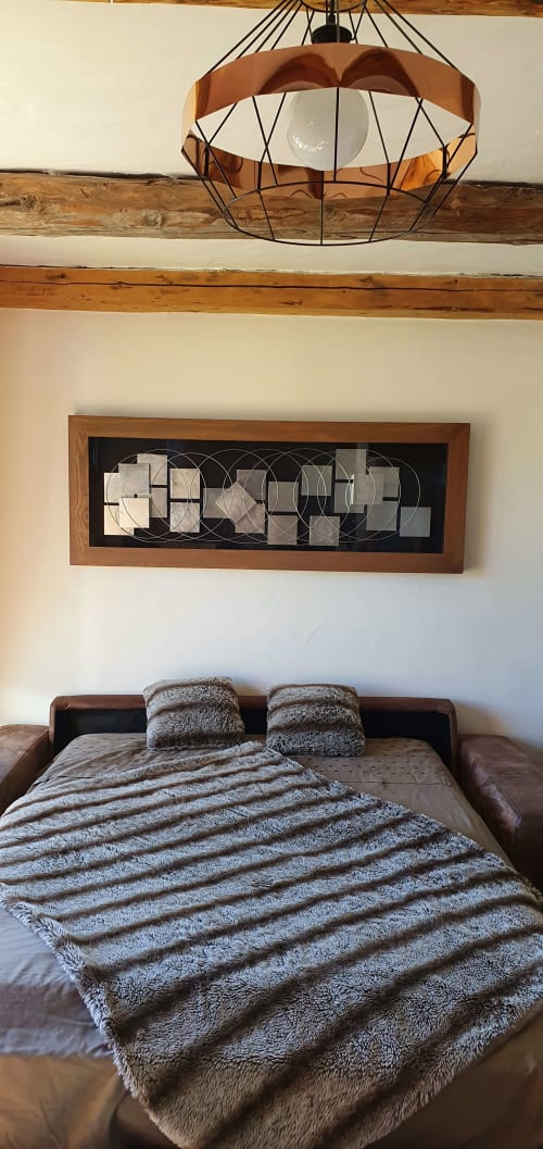 Chambre douillette à la Résidence Le Pacha avec poutres en bois, décoration murale géométrique et literie rayée à Courchevel