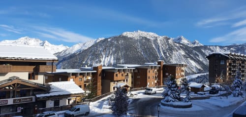 Résidence Le Pacha à Courchevel avec montagnes enneigées, immeubles d'appartements de luxe et paysage alpin