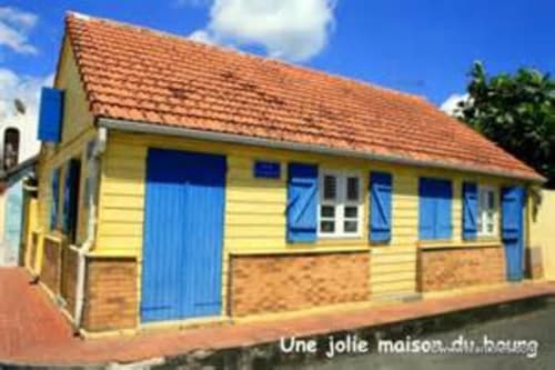 Petit gîte jaune aux volets bleus et toit en terracotta à Résidence de Vacances Mon Refuge, Les Anses d'Arlet, Martinique