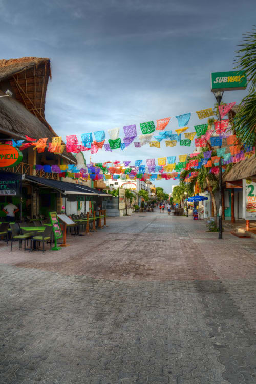 Colorida calle mexicana en Mareazul Beachfront Resort en Playa del Carmen con vibrantes decoraciones de papel picado y ambiente tropical