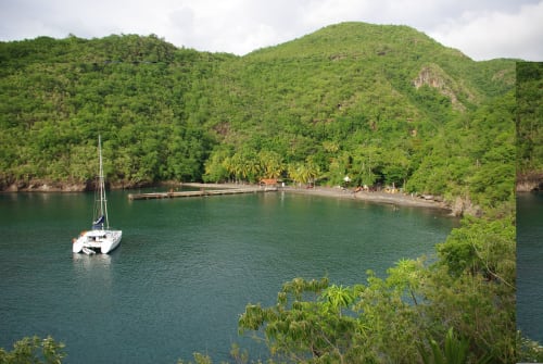 Voilier mouillé en baie turquoise à l'hôtel Mon Refuge, Les Anses d'Arlet, Martinique, entouré de montagnes luxuriantes