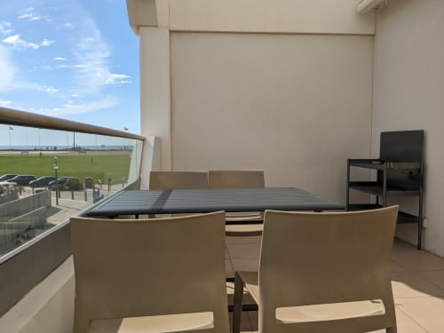 Coin salon sur le balcon de l'appartement Cote Et Dune à Biscarrosse Plage avec vue sur l'océan et le terrain de sports