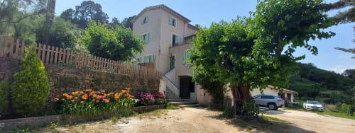 Le Mas de Trépeloup, gîte rural en Alès avec bâtisse en terre cuite, jardins fleuris et entrée bordée d'arbres