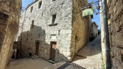 Bâtiments historiques en pierre et cour pavée du gîte Le Mas de Trépeloup à Alès