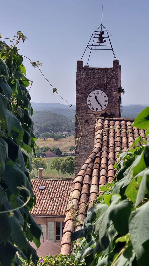 Tour horloge historique au Mas de Trépeloup à Alès, France, avec toit en terre cuite et végétation luxuriante