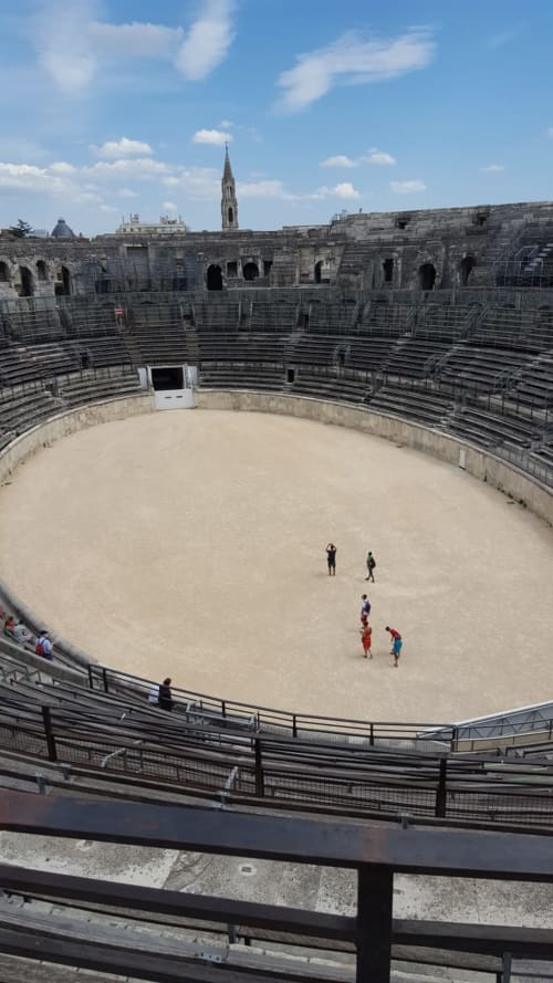 Arène de l'amphithéâtre romain de Nîmes près d'Alès, France avec spectateurs assis dans les gradins en pierre