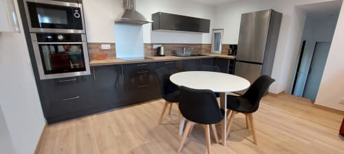 Cuisine et salle à manger modernes au gîte Le Mas de Trépeloup à Alès avec mobilier noir et table ronde blanche