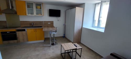 Petite cuisine moderne avec placards jaunes, coin repas et espace de vie à Le Mas de Trépeloup à Alès
