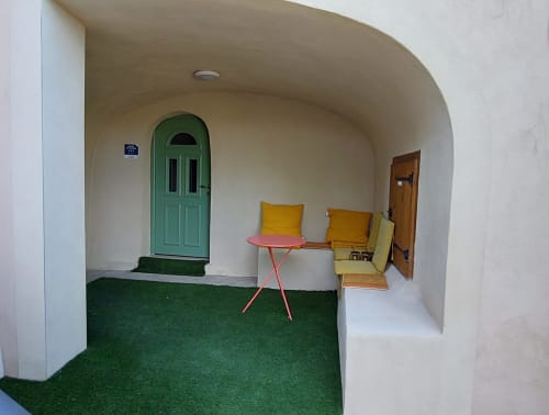 Chambre chaleureuse au Mas de Trépeloup à Alès avec porte verte, siège jaune et table rouge
