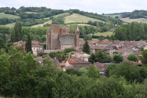 Medieval church and stone village nestled in rolling green countryside hills near Monties, France
