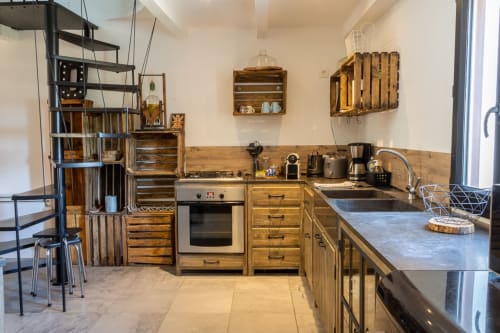 Cuisine rustique au Mas Lafleur à Châteaurenard avec caisses en bois, appareils inox et plans de travail foncés