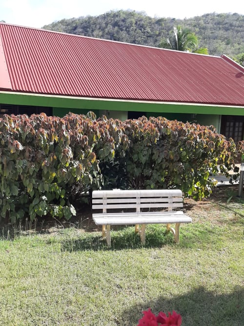 White bench in lush garden at Mon Refuge hotel, Les Anses d'Arlet, Martinique