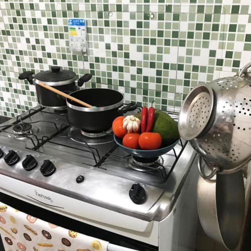 Fogão a gás com utensílios de cozinha e vegetais frescos na cozinha do Hostel New Ipanema, Rio de Janeiro
