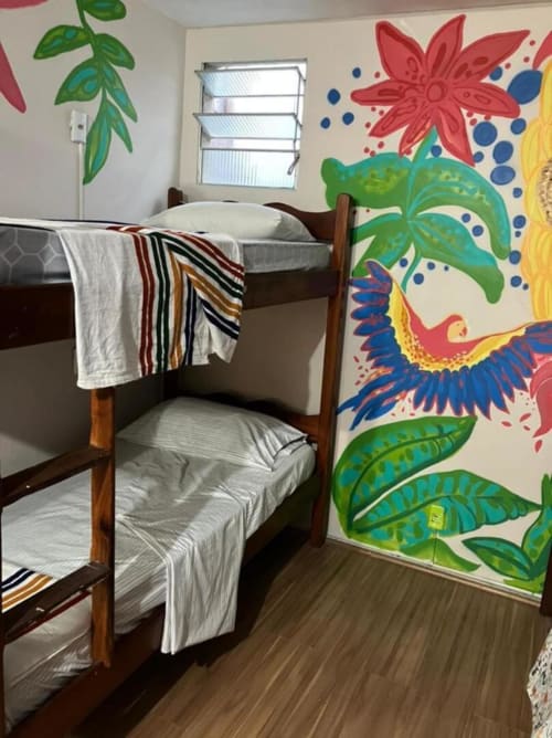 Dormitório colorido com beliches e murais de flores tropicais na Hostel New Ipanema, Rio de Janeiro