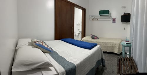 Dois leitos em quarto limpo do Pouso do Barão em Domingos Martins com vista para jardim e banheiro ensuite
