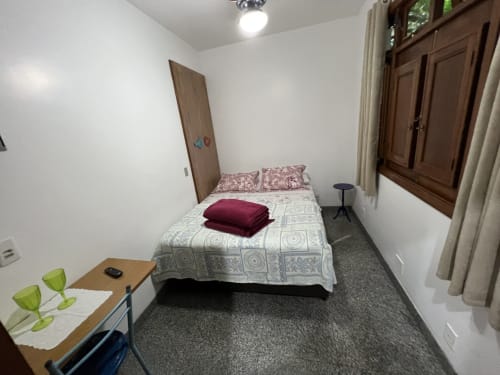 Quarto aconchegante no Pouso do Barão em Domingos Martins com cama de solteiro, escrivaninha e vista para o jardim pela janela ampla