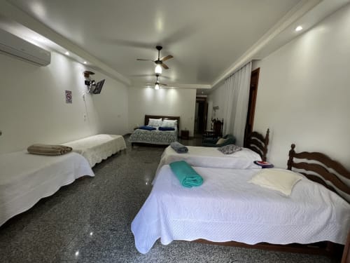 Quarto espaçoso com múltiplas camas no Pouso do Barão em Domingos Martins com vista para as montanhas