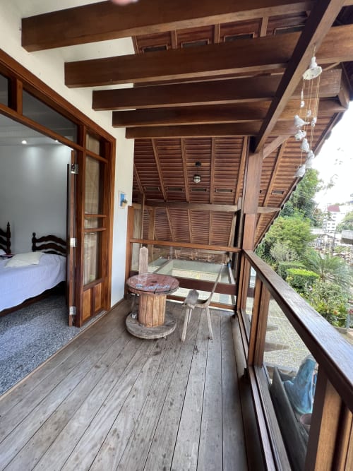 Varanda com deck de madeira e vistas da montanha no hotel Pouso do Barão em Domingos Martins, Brasil