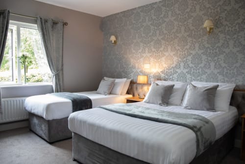 Bright double bedroom at Sliabh Beagh Hotel in Monaghan with twin beds, damask wallpaper, garden views, and modern amenities