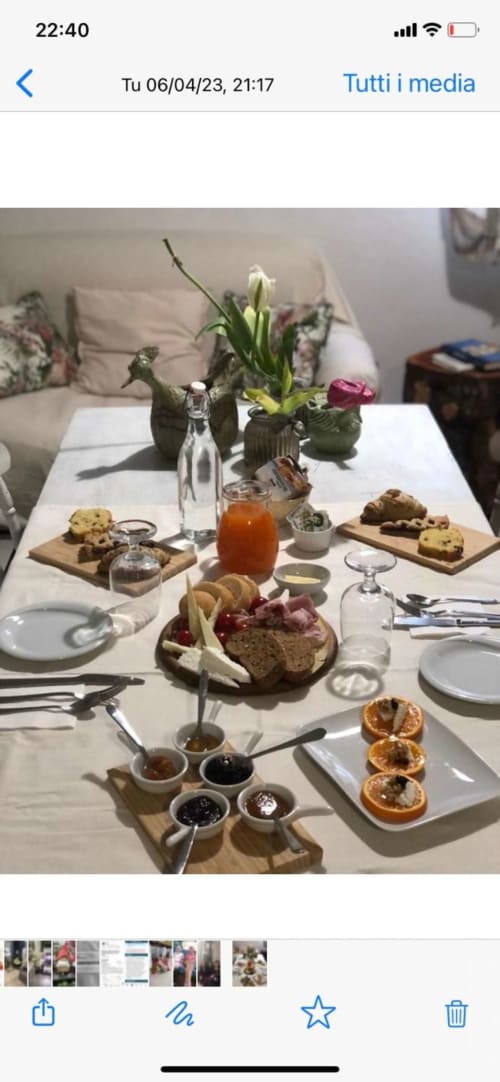 Elegante tavolo da colazione ad Agriturismo Il Pomo d'oro con pasticcini, marmellate, fiori freschi e bevande ad Assemini,