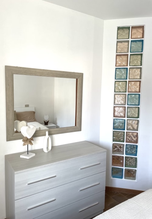 Moderna cassettiera in camera da letto con specchio e esposizione di piastrelle decorative nell'appartamento Varenna by Foot, Varenna, Italia