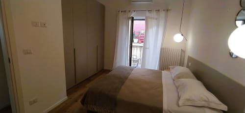 Camera moderna a Bari Vacation B&B con letto matrimoniale, accesso al balcone, guardaroba e TV a schermo piatto