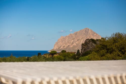 Dramatic rocky mountain rising from azure Mediterranean sea near Villa Maria, Sant'Andrea Valderice with sandy beach