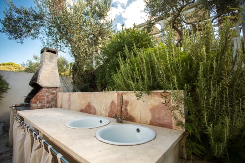 Outdoor sink area at Villa Maria overlooking the sea in Sant'Andrea, Valderice with cypress trees and rustic décor