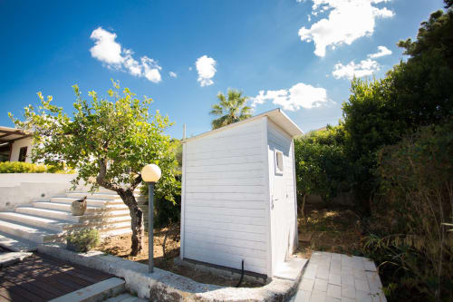 White utility shed with palm tree in garden at Villa Maria, Sant'Andrea Valderice
