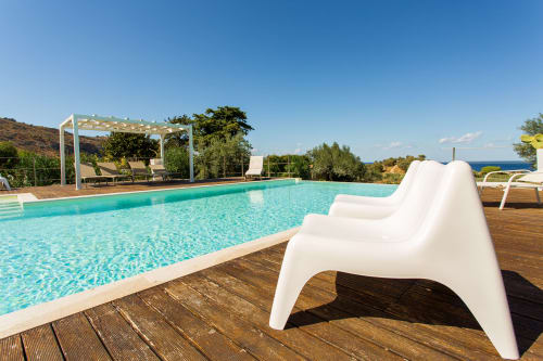 Luxury pool area at Villa Maria with turquoise water, white lounge chairs, and sea views in Sant'Andrea, Sicily