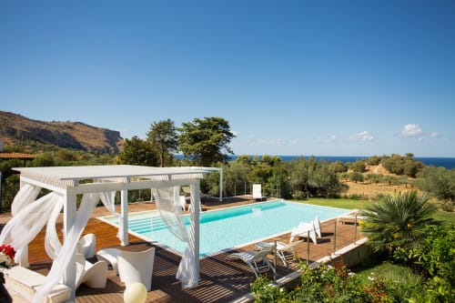 Luxury poolside terrace at Villa Maria with turquoise swimming pool, white pergola, sea views, Sant'Andrea Valderice Sicily