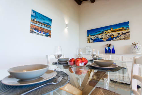 Elegant dining room at Villa Maria with place settings, fresh fruit, coastal artwork, and sea-view décor in Sant'Andrea