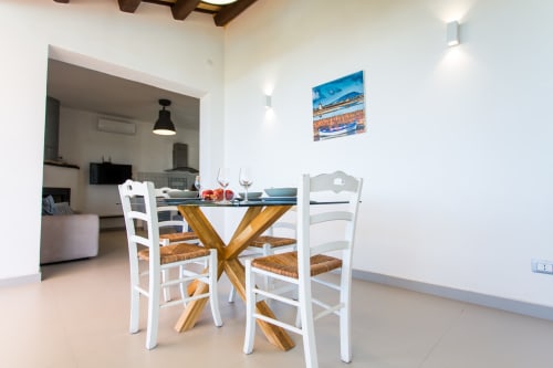 Dining area with white chairs and wooden table at Villa Maria, Sant'Andrea Valderice Sicily