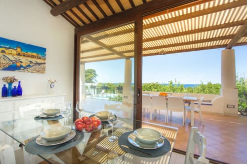 Elegant dining area at Villa Maria with sea view, set table, and terrace overlooking Mediterranean