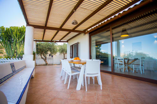 Spacious terrace at Villa Maria with wooden pergola, dining table, sea views, and Mediterranean garden in Sant'Andrea,