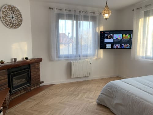 Chambre moderne à Toulouse avec TV écran plat, cheminée, vue sur balcon et décoration contemporaine