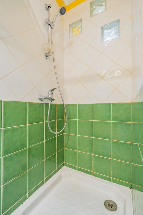 Salle de bain moderne avec carrelage vert et crème, pluie de douche et vitrage à l'appartement Room In Toulouse