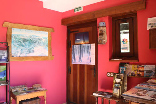 Luminoso vestíbulo rojo del hotel Casa Lafuente en Lukiano con puerta de madera, fotografías de viajes e información turística local