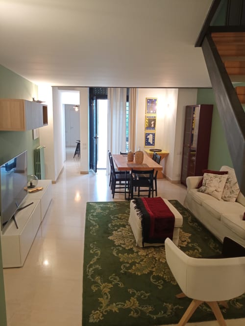 Ampia zona living e cucina open-plan in villa Villetta Marianna a Bari con tavolo in legno, dettagli in damasco verde