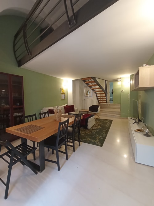 Zona living e pranzo open-plan moderna di Villetta Marianna, villa vacanze a Bari con pareti verdi e scala in legno
