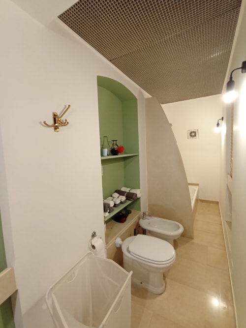 Bagno moderno nella villa Villetta Marianna a Bari con arredamento contemporaneo, sanitari bianchi e scaffalature verdi.