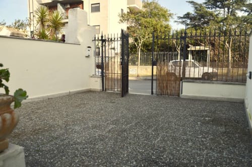 Ingresso di Villa Marianna a Bari con cancellata in ferro nero, cortile in ghiaia e giardino in stile mediterraneo