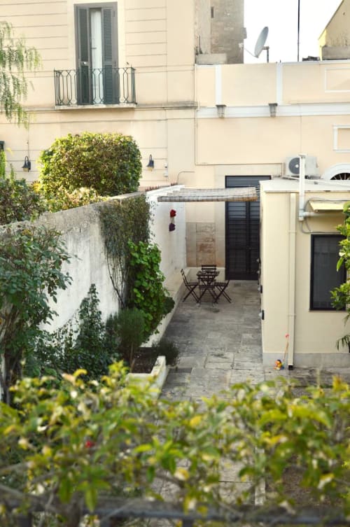 Giardino privato della villa Villetta Marianna a Bari con muri ricoperti di edera, area relax e vegetazione rigogliosa