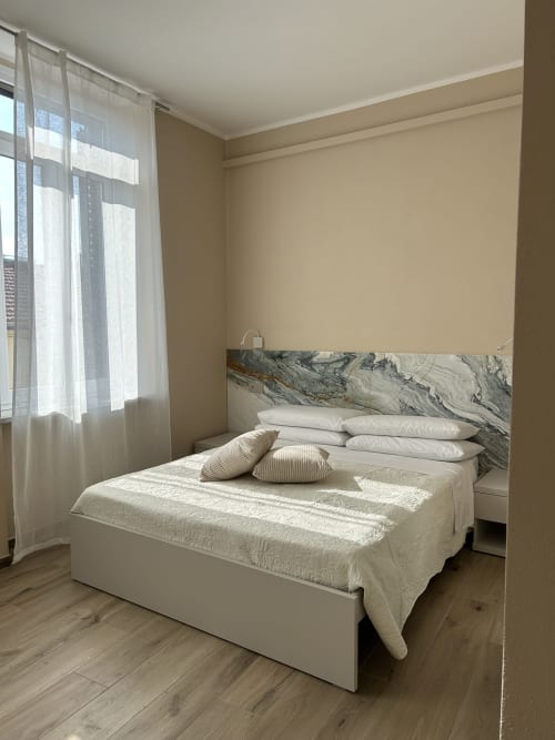 Camera moderna presso il Breccia nel Mare B&B a Marina di Carrara con testata in marmo, biancheria bianca e luce naturale