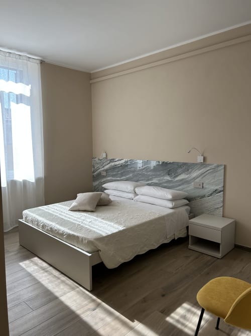 Camera moderna al Breccia nel Mare B&B di Marina di Carrara con testata in marmo, biancheria bianca e luce naturale da
